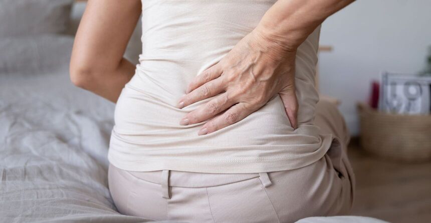 Frau berührt ihren unteren Rücken. Bild: fizkes von Getty Images via CanvaPro Frau berührt ihren unteren Rücken. Bild: fizkes von Getty Images via CanvaPro