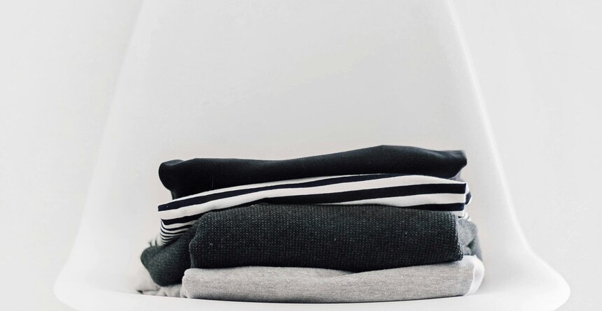 Stapel mit gefalteter Kleidung für eine Frau. Bild: Sarah Dorweiler via Unsplash Stapel mit gefalteter Kleidung für eine Frau. Bild: Sarah Dorweiler via Unsplash