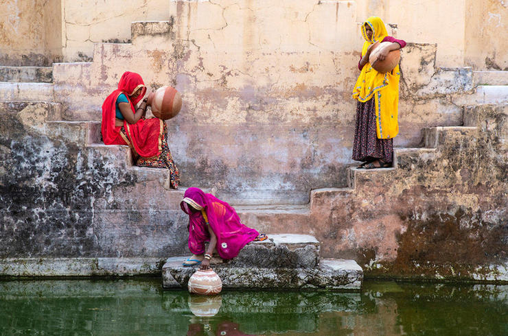 Frauen in Bunten Kleidern holen Flusswasser